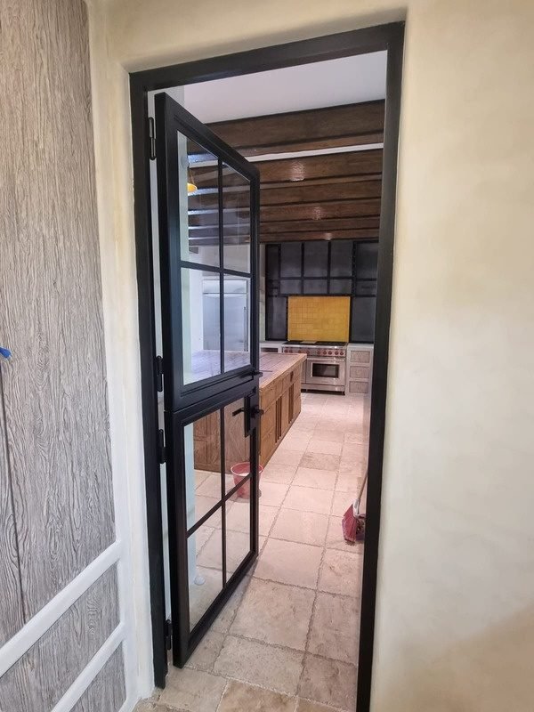 Puerta de acero con cristal y cuarterones hacia la cocina