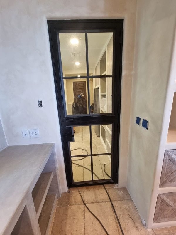 Puerta de acero y cristal en pasillo interior
